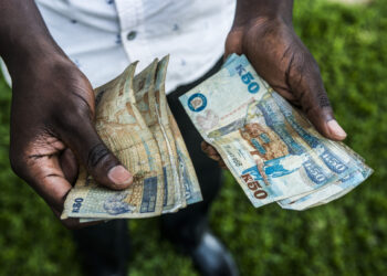 A man counts out Zambian kwacha 50 denomination banknotes in this arranged photograph in Lusaka, Zambia, on Thursday, Oct. 8, 2015. Zambian Finance Minister Alexander Chikwanda is seeking to restore confidence in the economy to help reverse the world's worst currency performance, record borrowing costs and sliding growth. Photographer: Waldo Swiegers/Bloomberg